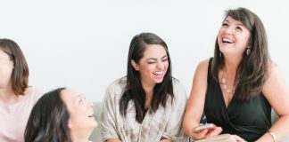 women laughing sitting on a couch