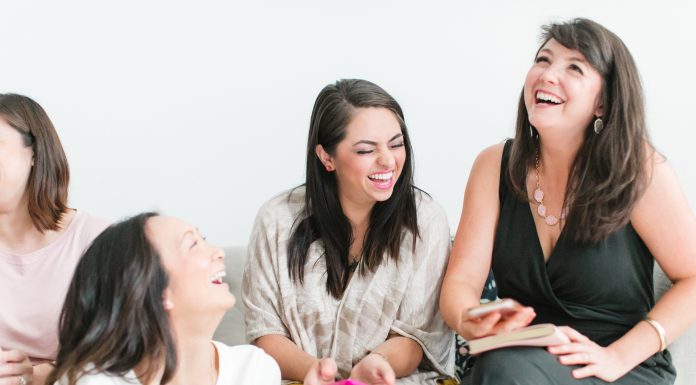 women laughing sitting on a couch