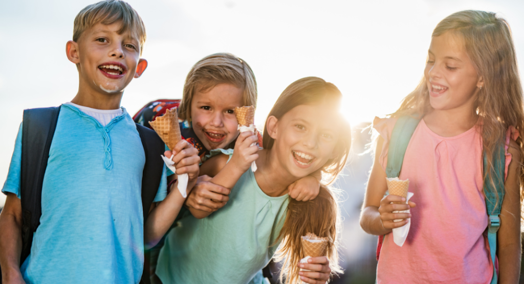 group of children with backpacks eating ice cream